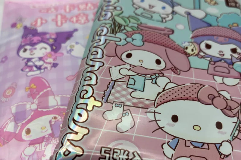 Two sealed Sanrio card packs, one mint green and one pink, printed with Hello Kitty, My Melody and Kuromi.